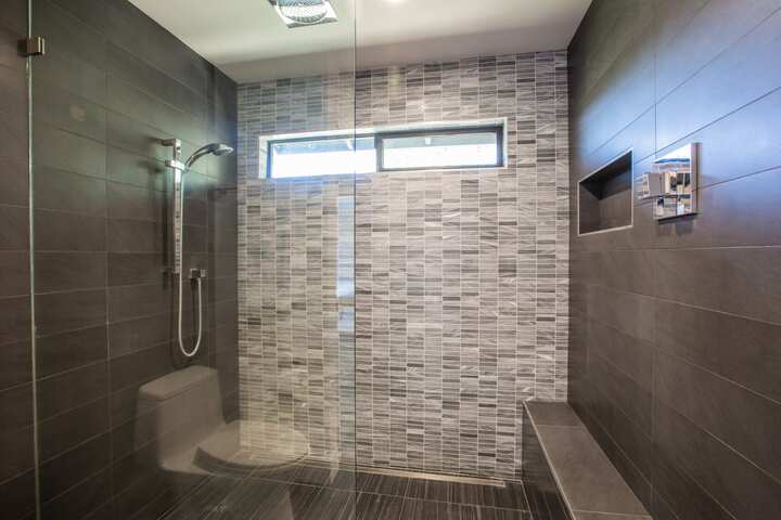 A large shower installation with dark tile for Rancho Cucamonga, California home